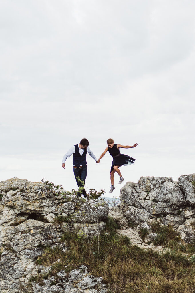 Hochzeitspaar auf einem Felsen, Braut ist in der Luft nach Sprung